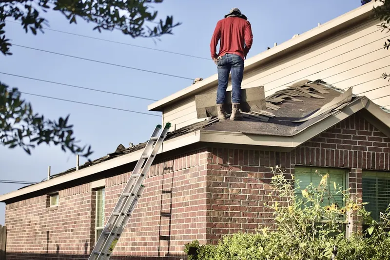 Professional roofer working on a residential roof in Kaser